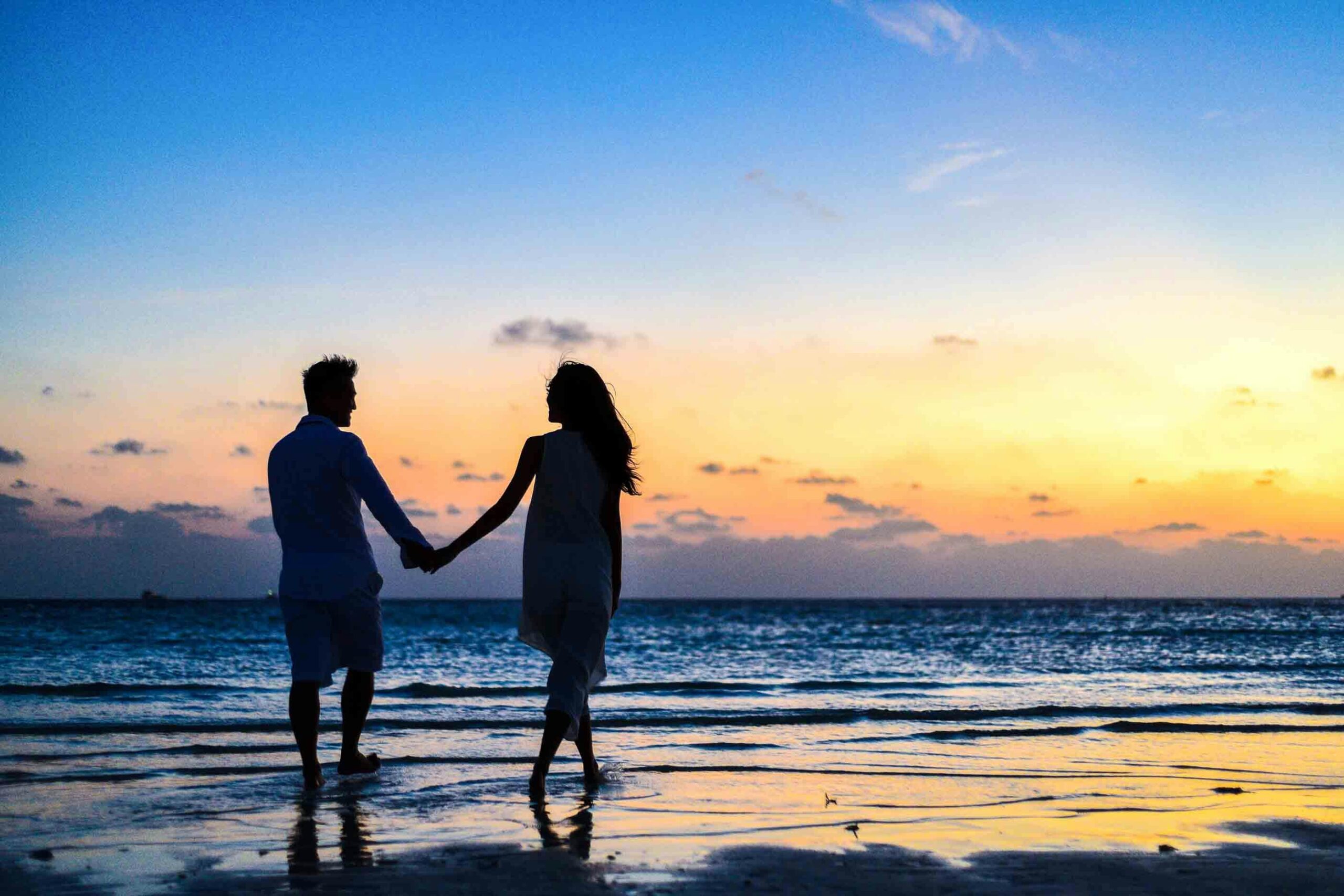 couple en contre jour sur la plage au coucher de soleil